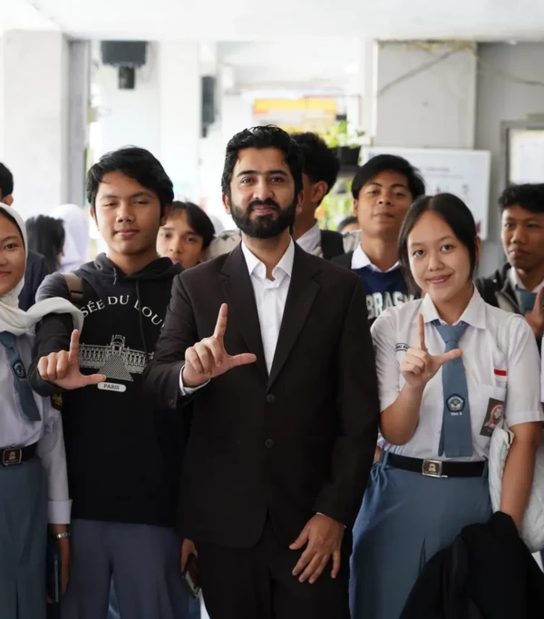 Sekelompok pelajar dan pengajar berfoto bersama di sekolah, menunjukkan sikap positif dan kebersamaan.